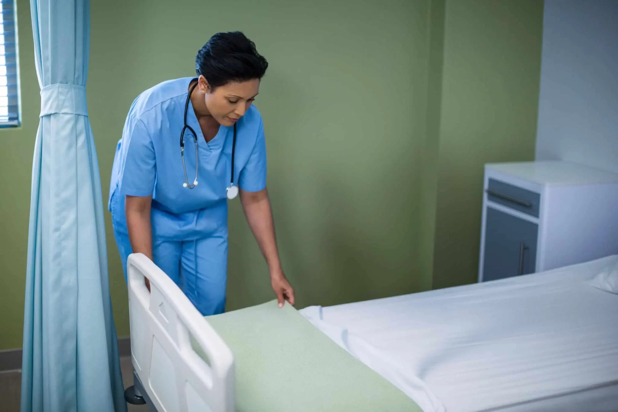 asian-nurse-in-scrubs-stethoscope-tucking-blanket-2026-01-08-23-34-42-utc