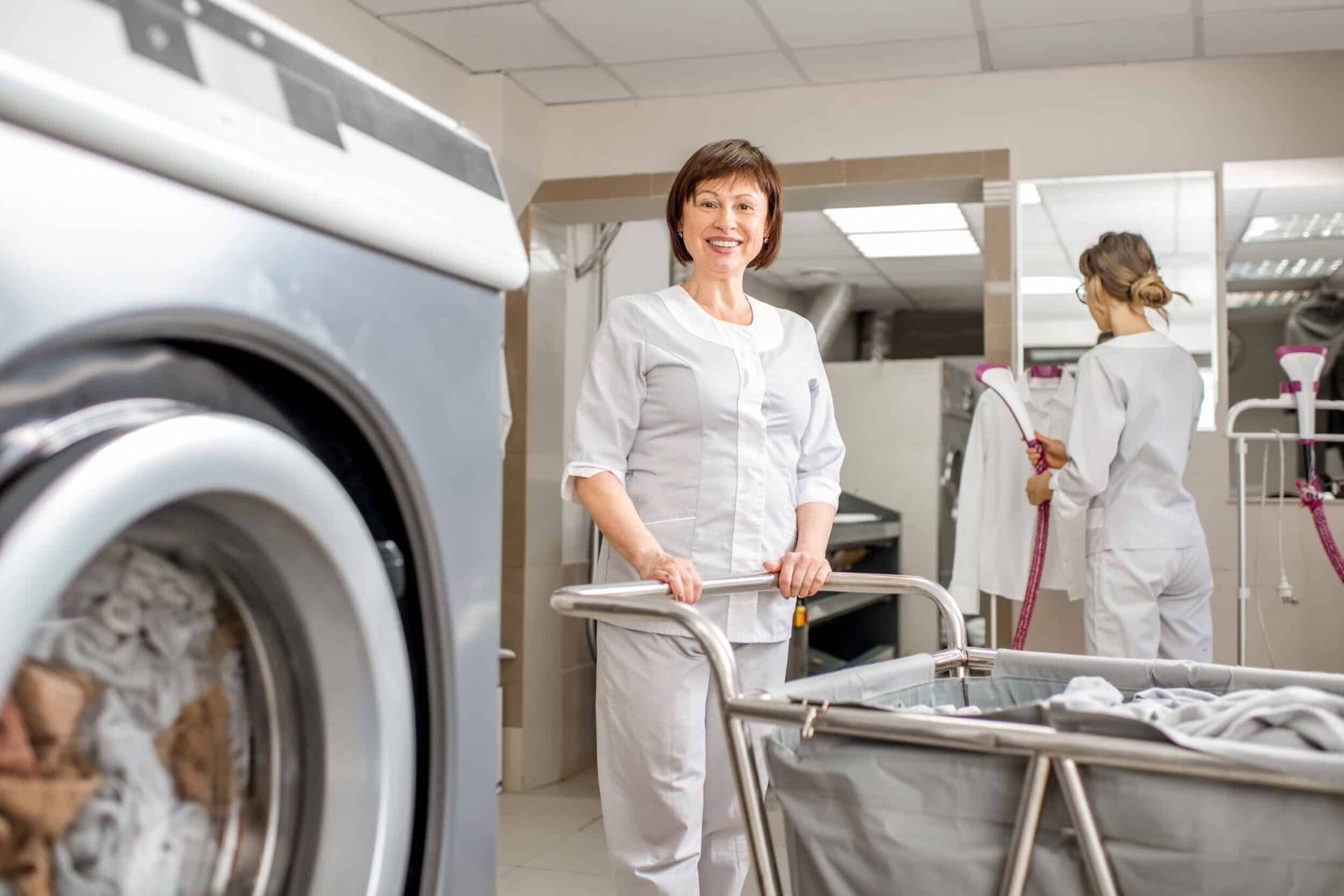 laundry-worker-smiling-near-industrial-washing-mac-2026-01-08-22-45-15-utc (1)